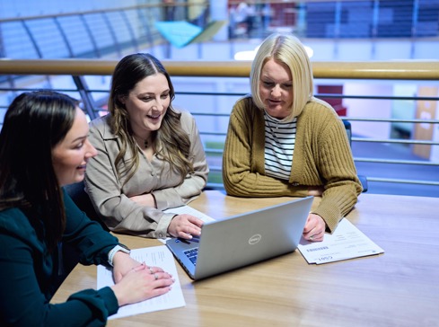 Three white female corporate lawyers discussing a transaction