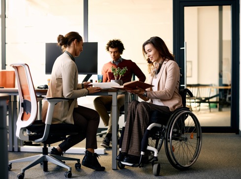 Wheelchair user at a team meeting in a business setting talking about employment law