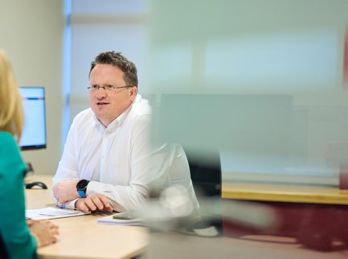 White male property dispute lawyers in office with back of colleague in shot